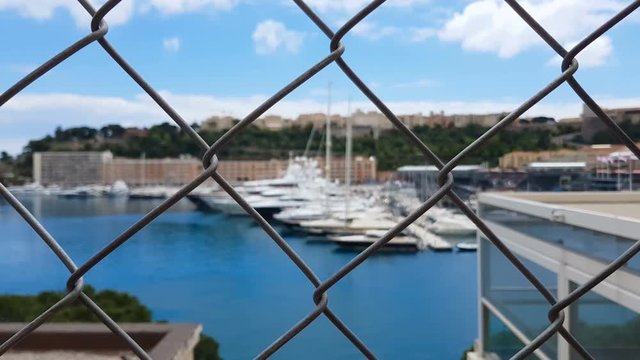 Man views yachts behind fence, corrupt official looks at confiscated property
