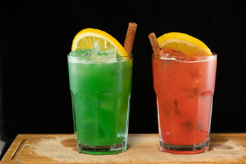 Red and Green Cocktails with red and green juices, alcohol and lime wedge