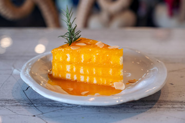 Closeup image of a piece of orange cake on ceramic plate