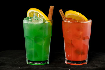 Red and Green Cocktails with red and green juices, alcohol and lime wedge