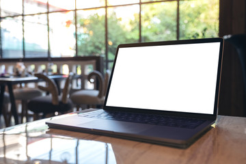 Mockup image of laptop with blank white desktop screen on table in cafe