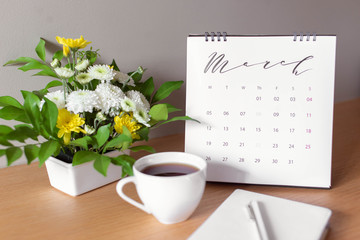  Woman's desktop with coffee, flowers and calendar. Planing