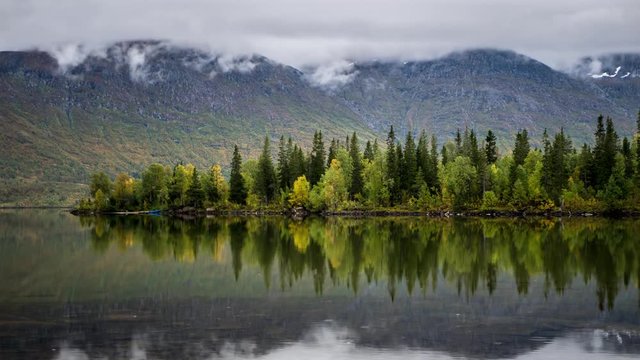 Timelapse in Norway in Ultra High Definition with wild lake in the foreground and generating clouds in the background.