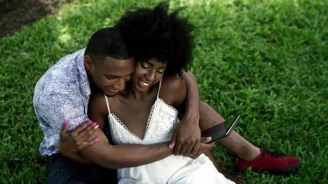 Young Black Couple Using Technology in the Park. Laptop, Tablet, phone. Miami beach Florida US
