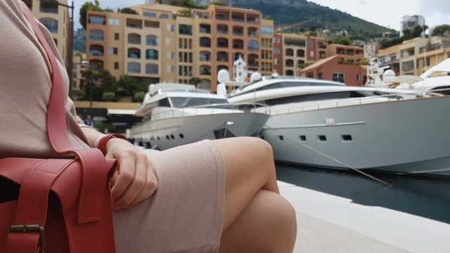 Woman sitting near pier, opened purse as concept of pickpocketing in resorts