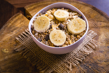 Bowl of cereal with fruit, pieces of banana with oats and cereal.