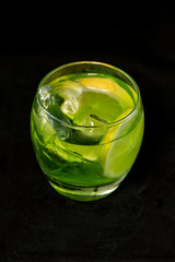 Green cocktail with gin, bitter lemon, basil and lemon