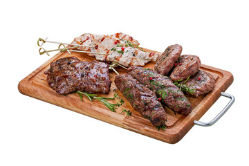 Set of grilled meat on a wooden Board. Chicken fillet, beef steak, pork medallion, lamb kebab. On a white background