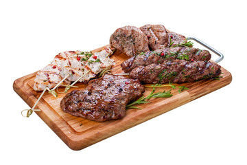 Set of grilled meat on a wooden Board. Chicken fillet, beef steak, pork medallion, lamb kebab. On a white background