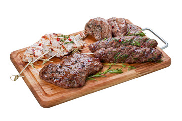 Set of grilled meat on a wooden Board. Chicken fillet, beef steak, pork medallion, lamb kebab. On a white background