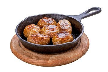 Baked whole potatoes in the pan. On a white background.