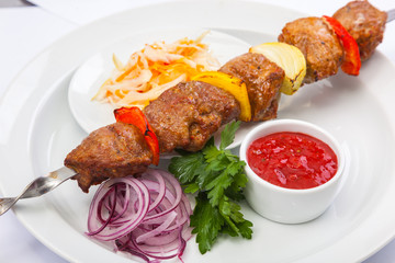 shashlik on skewer with red sauce