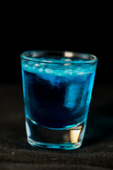 Jellyfish shot cocktail with blue curacao, sambuca, vodka and milk