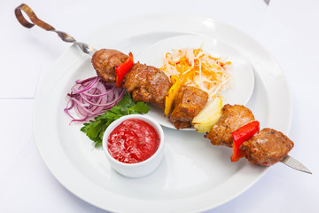 shashlik on skewer with red sauce