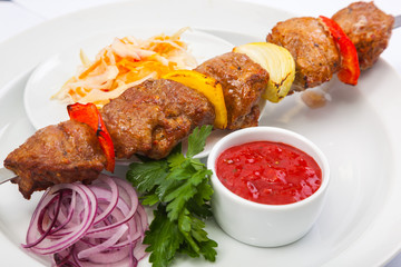 shashlik on skewer with red sauce