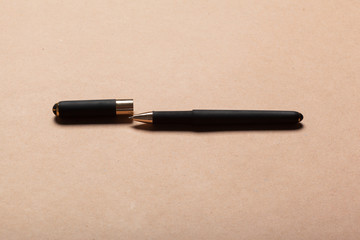 Black luxury ball point pen on beige background