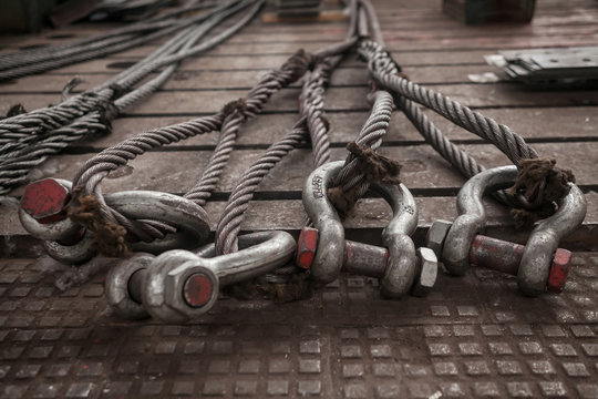 Hoist chains, chain hook wheel alignment, Chain hoists for heavy lifting, tow black crane hooks on a floor with white dust of construction Site