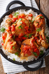 Haitian Chicken Recipe is a one pot of chicken, tomatoes, wine, spices, and rice close-up. Vertical top view