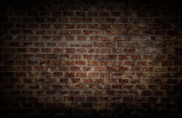 darkness theme. background and wallpaper or texture which has dim light of dark discolored old brick wall ancient vintage retro style have damage and cracks.