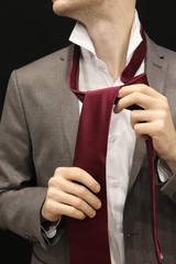 The Man Hands Are Correcting The Tie And Getting Ready To The Wedding or Work. Handsome Man in suit with tie.