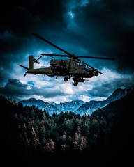 Fototapeta na wymiar Heavy armed attack helicopter flies over hills