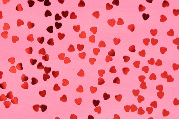 Pink background with red confetti hearts for Valentine Day