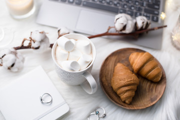 Cozy winter bloggers white work space with laptop, coffee with m