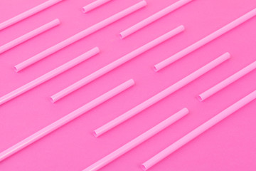 Drinking straws on bright pink background, top view