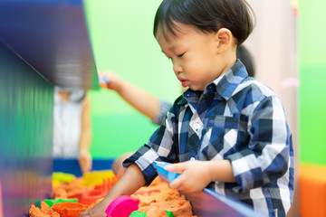 Fototapeta premium A boy is playing science sand at the playground.