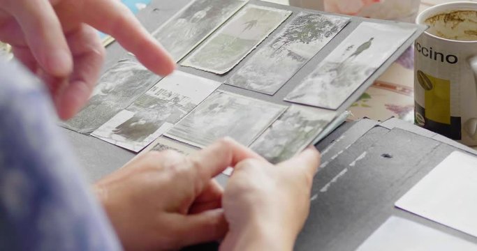 Woman pointing to old family photos in an album. Flat plane