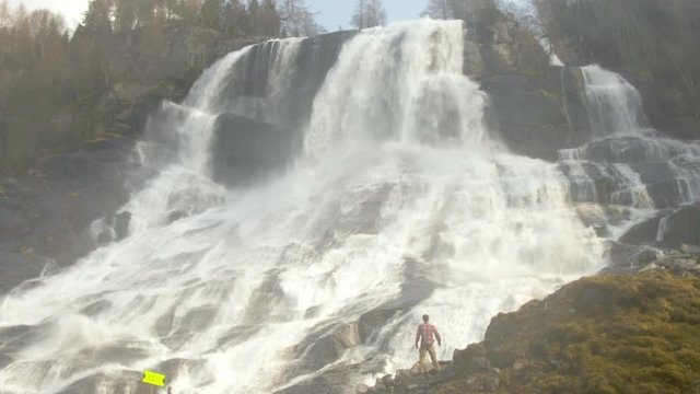 A Hiker Enjoys the Incredible View of the Furebergfossen Waterfall in Norway, Slow Motion