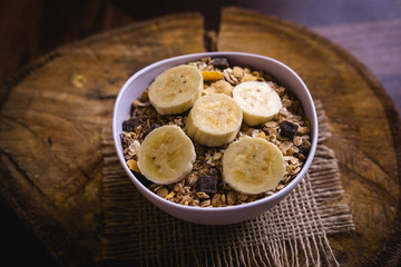 Bowl of cereal with fruit, pieces of banana with oats and cereal.