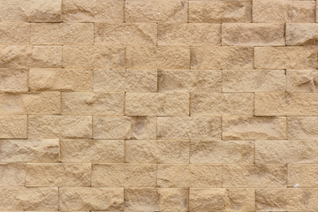 Horisontal yellow brick wall background texture closeup.