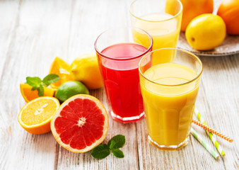 Glasses of juice and citrus fruits