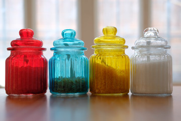 brown rock sugar in red yellow blue glass jar pot