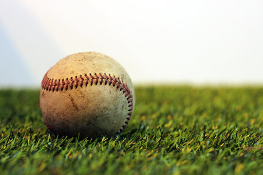 Old baseball on grass background