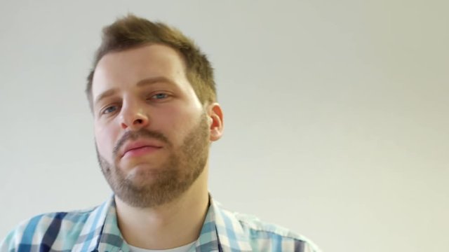 Young stylish and trendy caucasian man with a beard is dancing on a white background, close-up, hairstyle