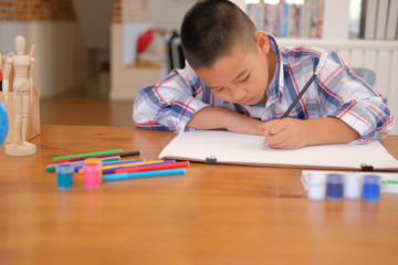 asian kid boy child schoolboy drawing picture. children activity at home