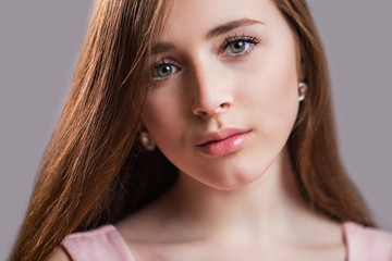 Fototapeta premium Horizontal closeup portrait of a beautiful young woman with clean skin, long eyelashes and natural beauty, fresh face. Green eyes, charming girl's