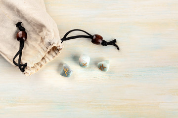 Norse runes, stones with symbols used in Wicca and other magic and for divination, tossed from a...