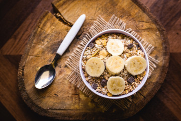 Bowl of cereal with fruit, pieces of banana with oats and cereal.
