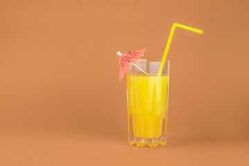 Orange cocktail drink on red background.  Image of citrus juice glass at bright minimalistic environment.