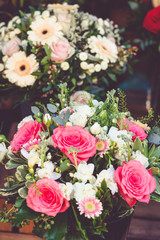 Beautiful bouquet with pink roses on a showcase in a French shop outside.