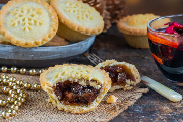 Traditional Christmas mince pies and mulled wine on wooden table