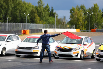 Starter gives the go-ahead red flag to start car racing