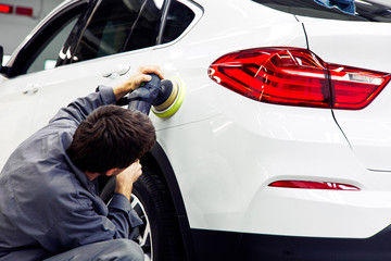 Car detailing - Hands with orbital polisher in auto repair shop