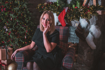 Sweet nice woman near christmas tree in cozy interior, holly christmas eve, magic new year with...