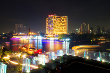 Fototapeta na wymiar Long exposure of Ship or Boat sailing in the Chao Phraya River at night time, Bangkok, Thailand. Lighting from water transportation. Beautiful of light trails.