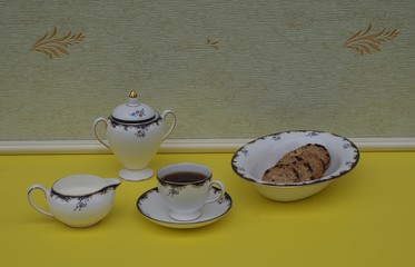 English teacup with saucer, cream jug, sugar bowl and a cake bowl with cookies, fine bone china...