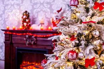 A traditional fireplace with lots of candles and christmas tree. Christmas decoration.